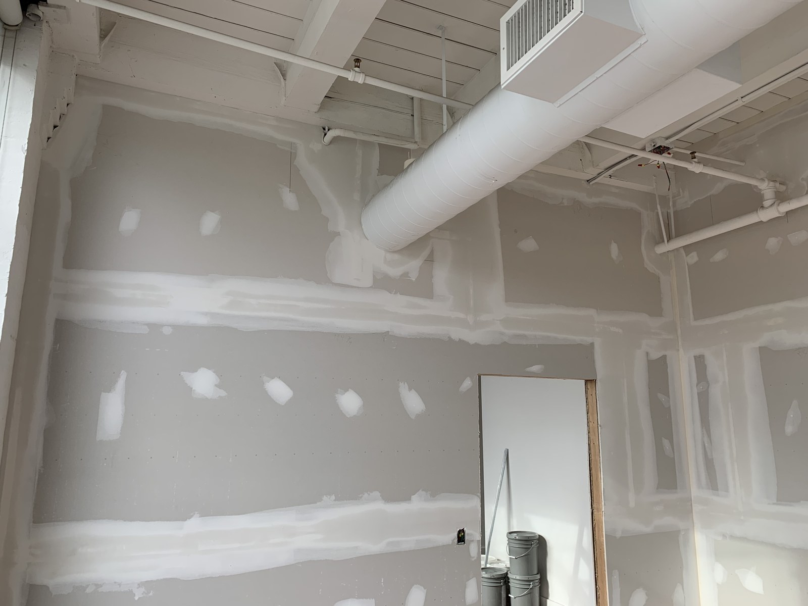 Drywall finishing around overhead building services